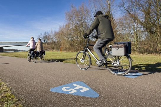 fietsers op fietssnelweg F5, logo F5 duidelijk zichtbaar op het jaagpad